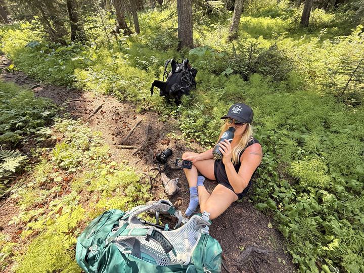 Stacie taking a rest stop on the forest trail on the way out