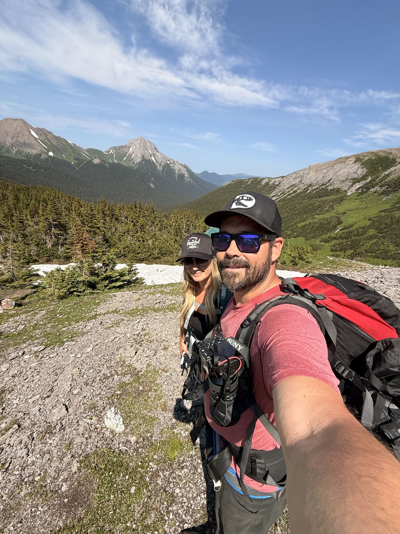 Stacie and Ryan with full packs above treeline on the Circular Route, with mountain peaks and a valley behind