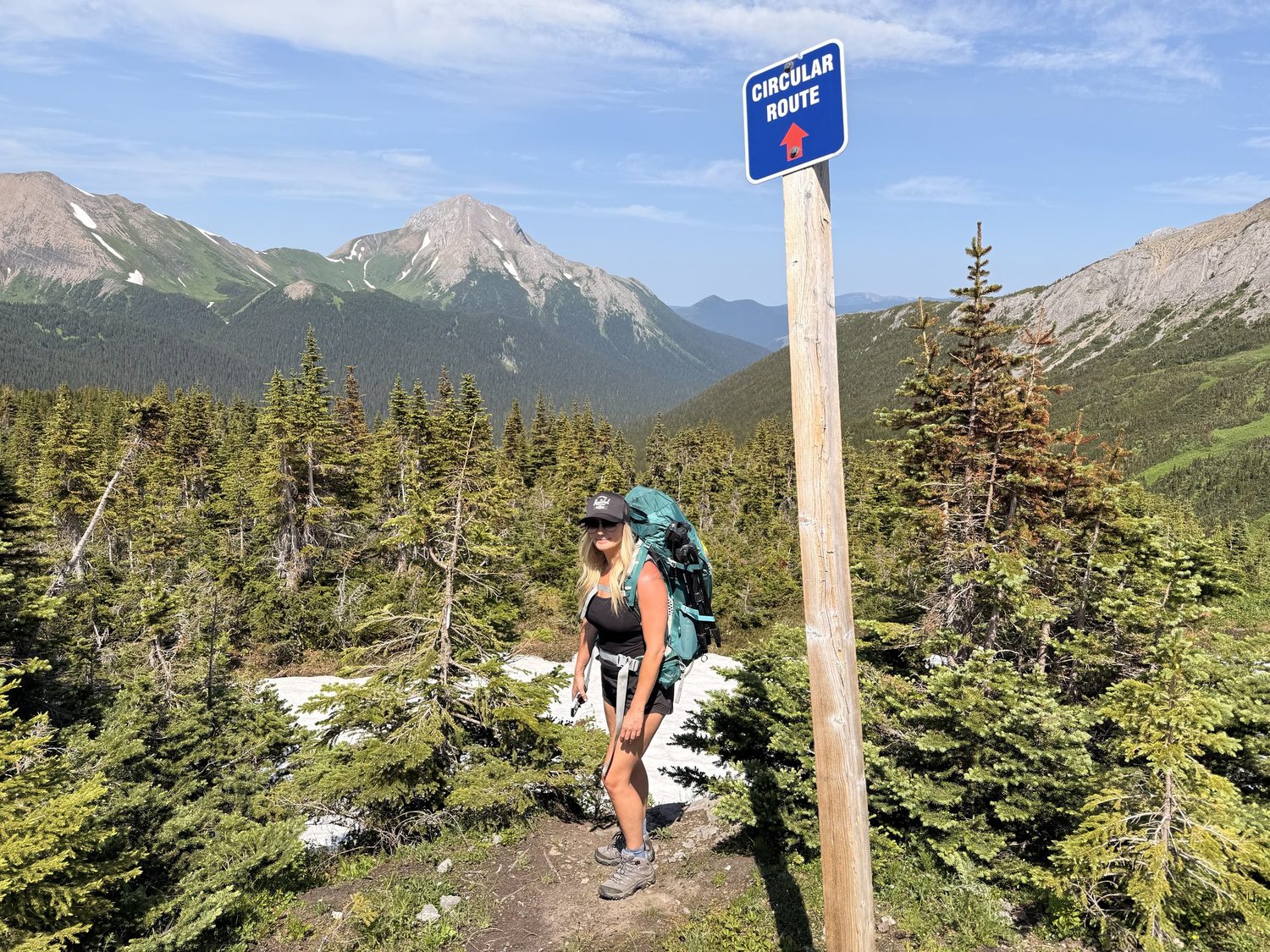 A trail marker on a Tumbler Ridge UNESCO Global Geopark route with the valley and mountains behind