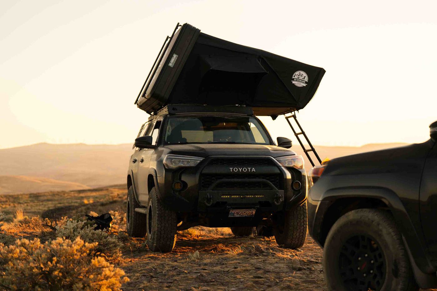 An open Go Overland tent at sunset