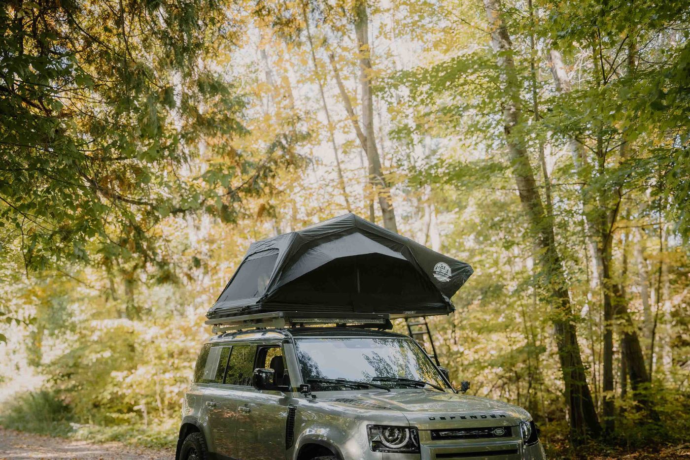 Voyage L rooftop tent open on a Land Rover Defender in the woods