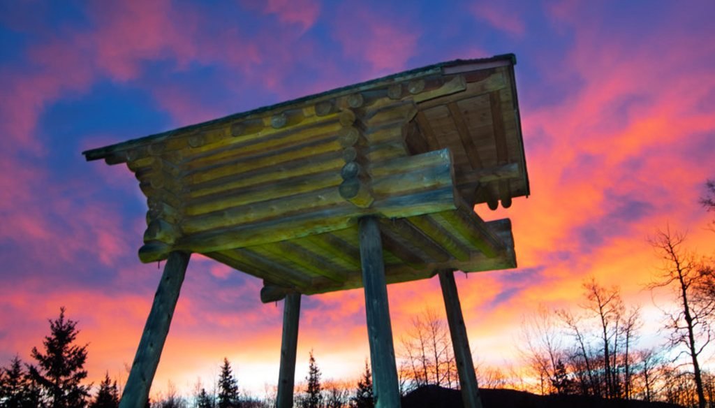 The namesake log cache in Grande Cache against a sunset sky