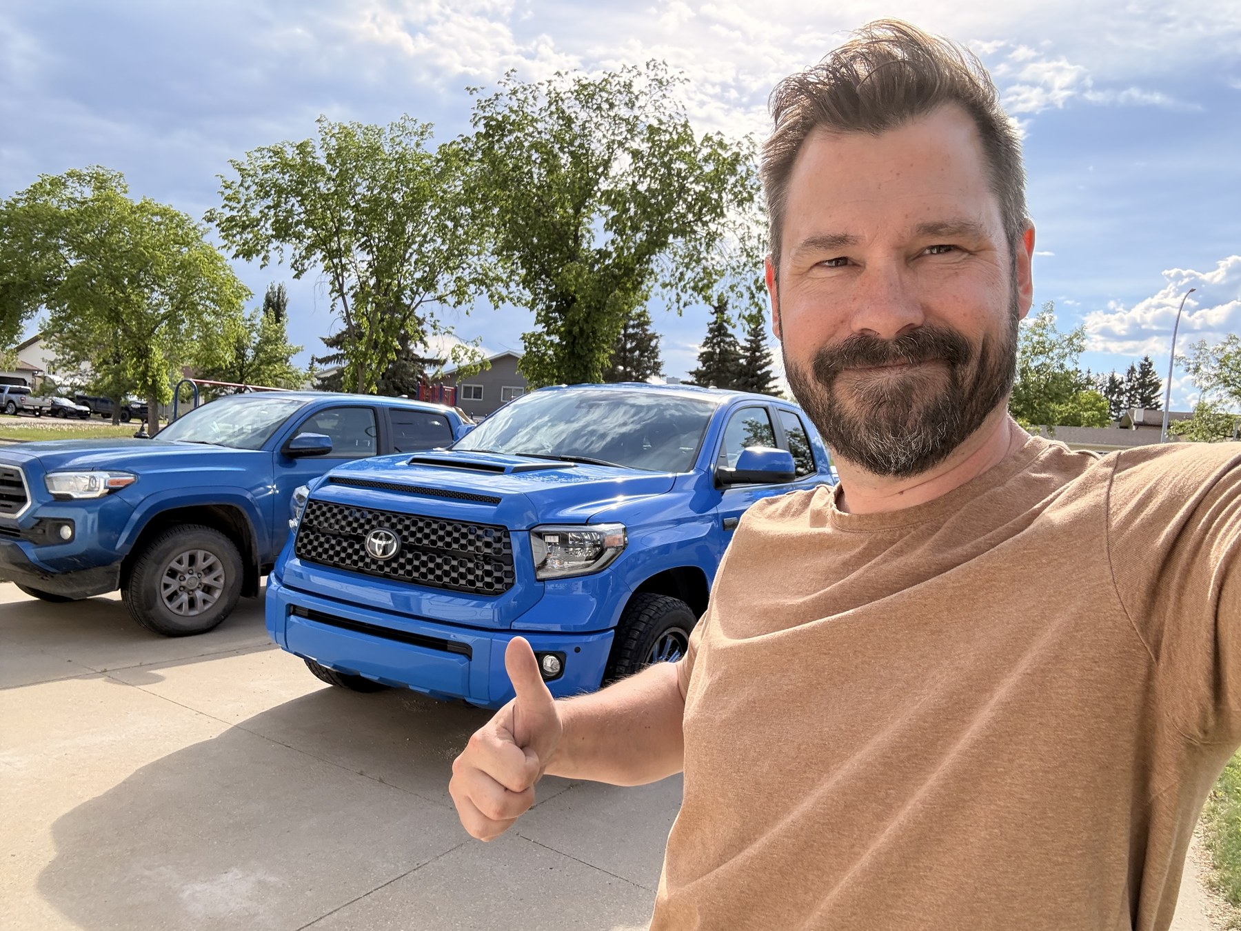 Ryan in the driveway with the Tundra and the 2016 Tacoma parked alongside it